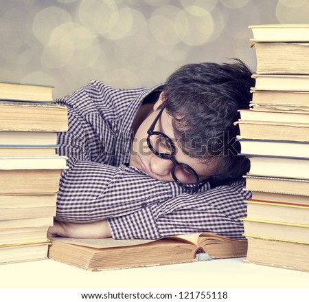 The young tired student with the books isolated. Photo with bokeh at background..