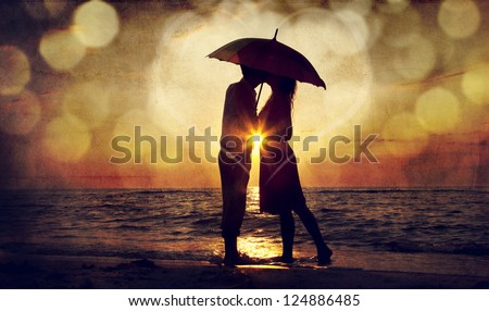 Couple Kissing Under Umbrella At The Beach In Sunset. Photo In Old Image Style.