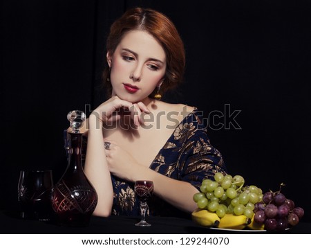 Portrait of beautiful rich women with grapes.