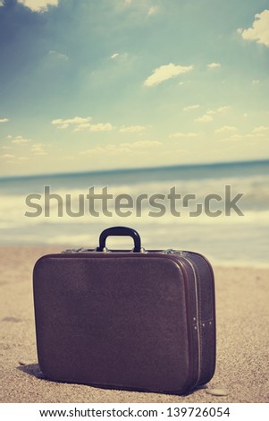 Retro Travel Suitcase Is Alone On A Beach