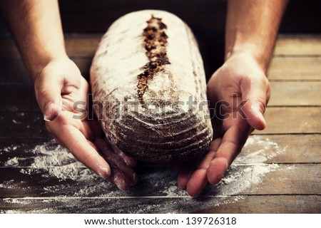Baker\'S Hands With A Bread. Photo With High Contrast