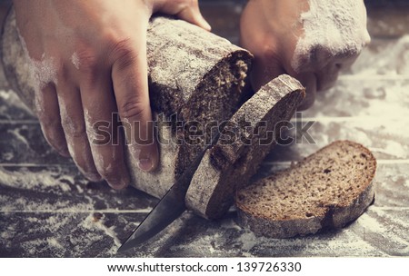 Male hands slicing home-made bread
