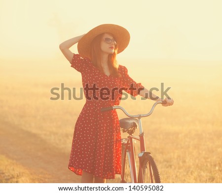 Girl on a bike in the countryside in sunrise time.