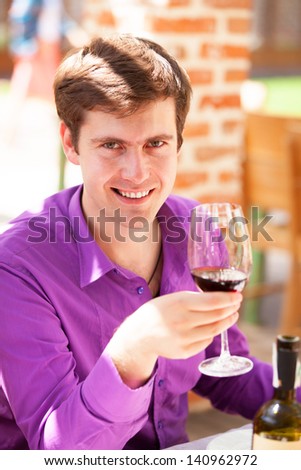 Man with wine in the cafe