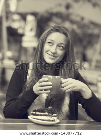 Style girl with cake and cup sitting in the cafe. Photo in black and white style.