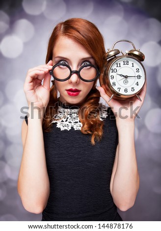 Surprised redhead girl with clock.