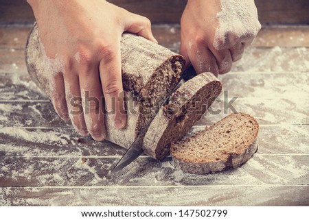 Male Hands Slicing Home-Made Bread