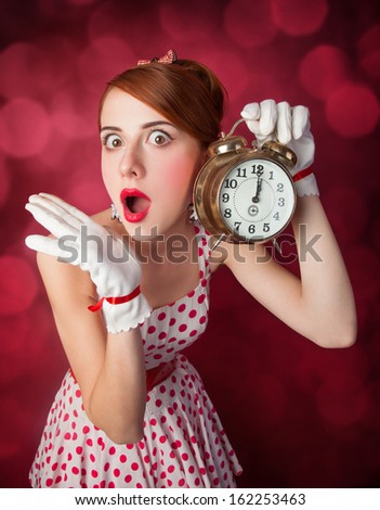 Beautiful redhead women with clock. Photo in retro style with bokeh at background.