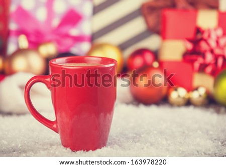 Cup of coffee and gifts at background