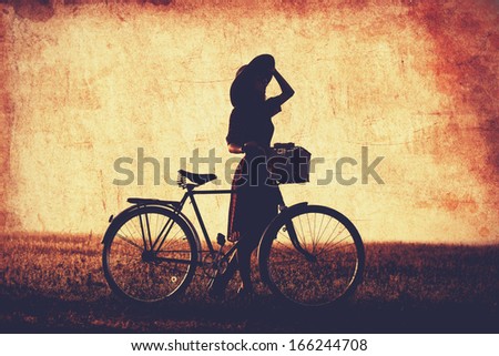Girl on a bike in the countryside in sunrise time.