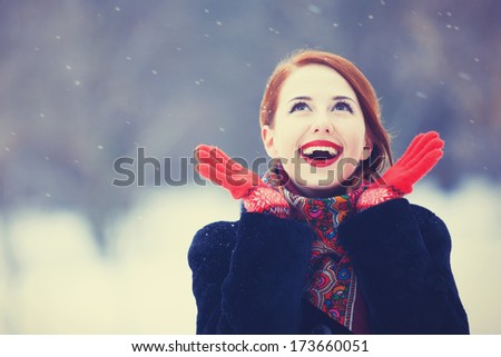 Beautiful redhead women with in winter park. Outdoor photo.
