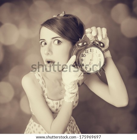 Beautifu women with clock. Photo in retro style with bokeh at background.