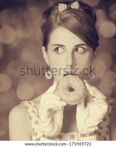 Beautiful women with donut. Photo in retro style with bokeh at background.