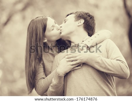 Couple kissing outdoor in the park. Photo in old color image style.