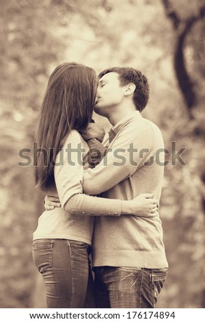 Couple kissing outdoor in the park. Photo in old color image style.