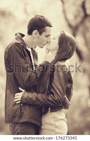 couple kissing outdoor in the park. Photo in old color image style.