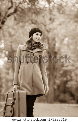 Women with suitcase at outdoor. Photo in sepia style.