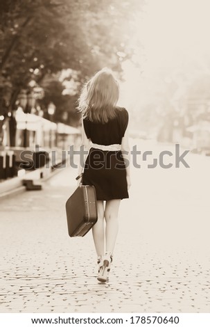 Young woman with suitcase on the city street