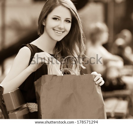 Style women sitting on the bench with shopping bags