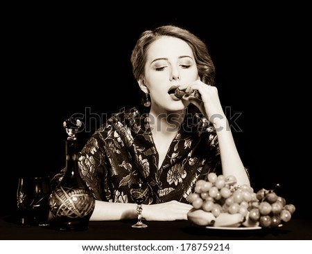 Portrait of beautiful rich women with grapes. Photo in old color image style.