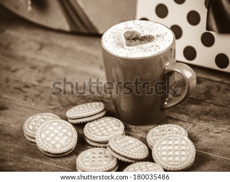 Cookies and cup of coffee with gifts at background