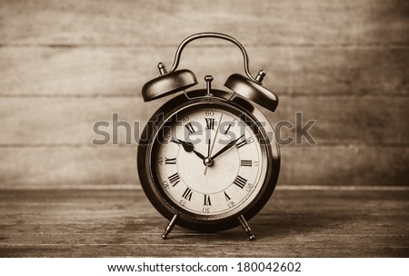 Retro alarm clock on a table. Photo in retro color image style
