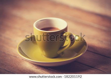 Little green cup of the coffee on a wooden table