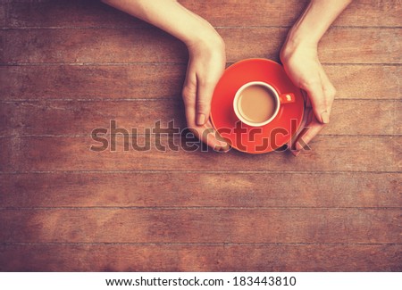 Female hands holding cup of coffee.