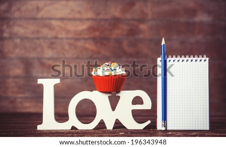 Cupcake, word Love and notebook with pencil