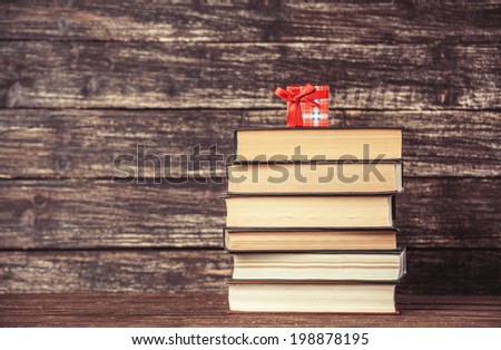 Gift and books on wooden table.