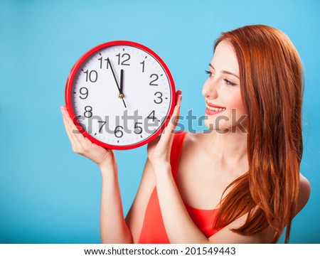 Redhead girl with huge clock on blue background.