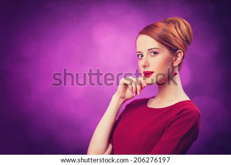 Beautiful redhead women on violet background.