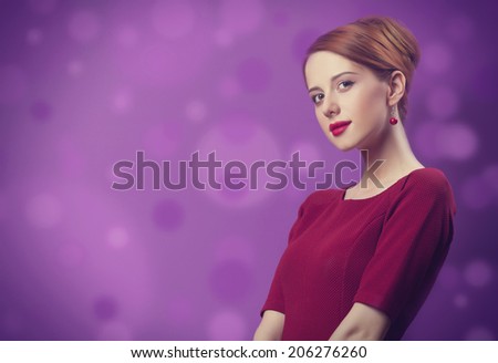 Beautiful redhead women on violet background.