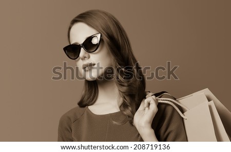 Portrait of a beautiful women with shopping bags. Photo in old sepia image style.