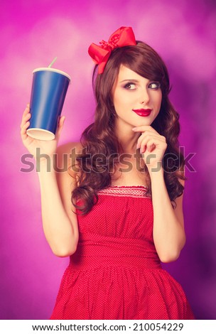 Brunette girl with bottle on violet background.