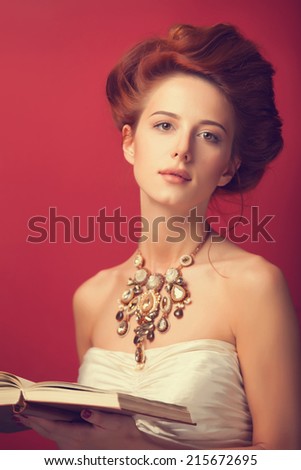 Portrait of redhead edwardian women with book on red background.