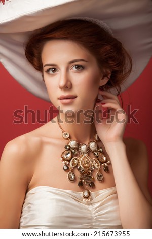 Portrait of redhead edvardian women on red background.