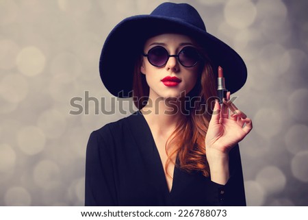 Style redhead women with sunglasses and lipstick.