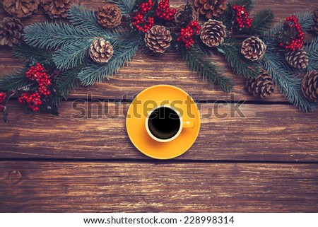 Hot coffee on wooden table near pine branches