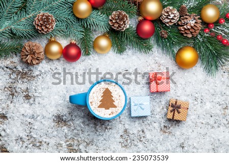 Cappuccino with christmas tree shape and gifts on artificial snow