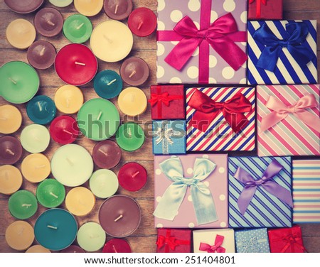 Gift boxes with candles on wooden background