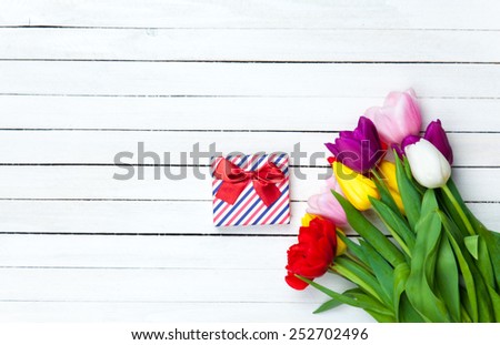 Gift box and tulips on white background