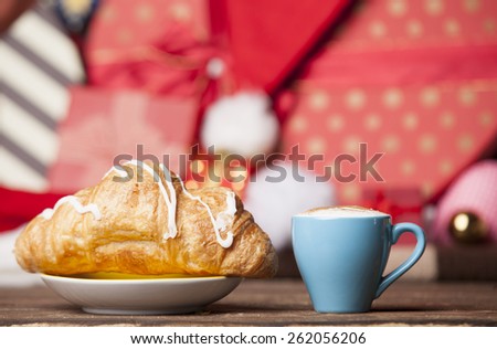 Cup of coffee and croissant on christmas background.