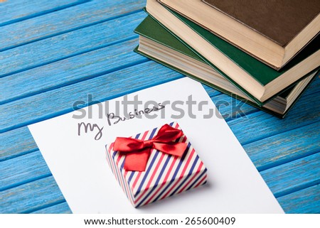 Gift boxes, books, pencil and paper with My Business words on blue background