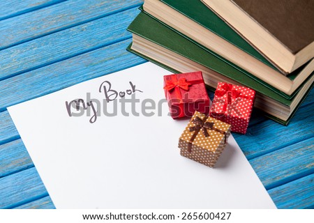 Gift boxes, books and paper with My Book words on blue background