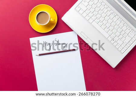 cup of coffee and computer with paper and pencil on red background