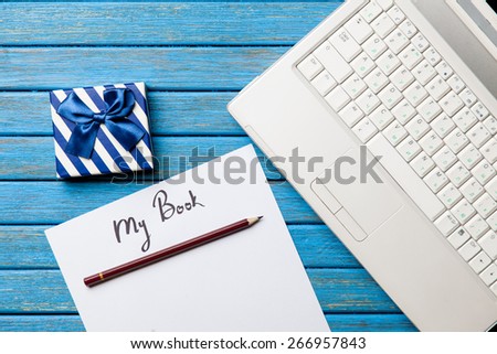 pencil and paper with My Book inscription near notebook on blue wooden table
