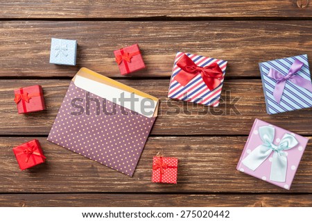 Gift boxes and envelope on  wooden table.
