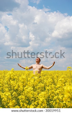 Men ar rapeseed field feel the power of nature