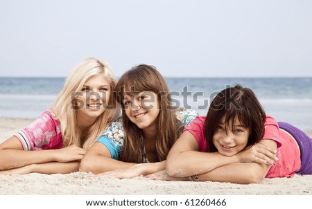 Three girlfriends lying down at the beach.